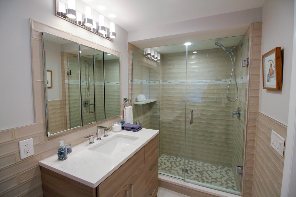 Medium sized contemporary ensuite bathroom in Newark with flat-panel cabinets, medium wood cabinets, an alcove shower, a two-piece toilet, beige tiles, porcelain tiles, beige walls, porcelain flooring, a submerged sink, engineered stone worktops, white floors, a hinged door, white worktops, a single sink and a freestanding vanity unit.