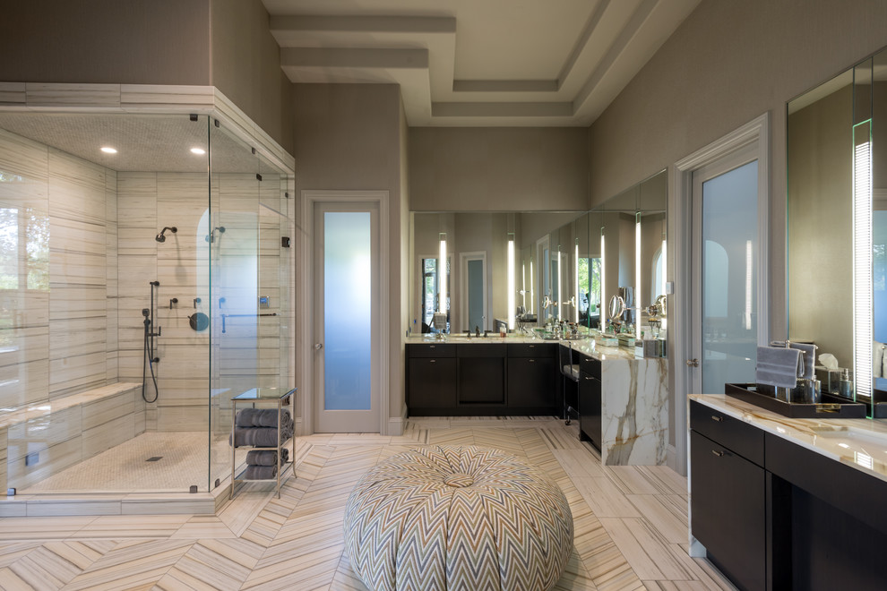 Inspiration for a large contemporary sauna bathroom in Dallas with flat-panel cabinets, dark wood cabinets, a freestanding bath, beige tiles, porcelain tiles, beige walls, marble flooring, a submerged sink and marble worktops.
