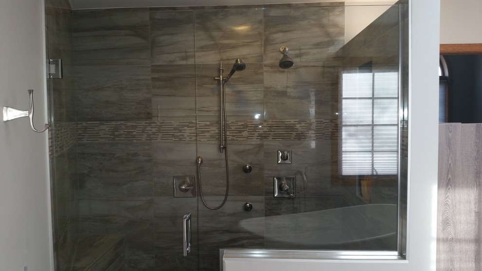 This is an example of a large contemporary ensuite bathroom in Chicago with shaker cabinets, medium wood cabinets, a freestanding bath, a double shower, a two-piece toilet, grey tiles, porcelain tiles, grey walls, porcelain flooring, a submerged sink and granite worktops.