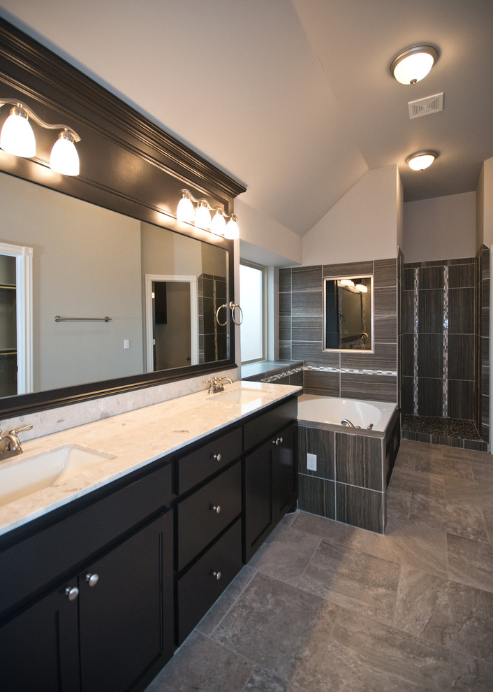 Inspiration for a large contemporary ensuite bathroom in Oklahoma City with a submerged sink, recessed-panel cabinets, black cabinets, marble worktops, a built-in bath, a corner shower, grey tiles, ceramic tiles, grey walls and ceramic flooring.