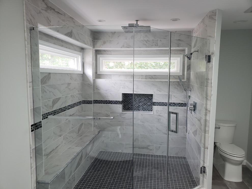 Inredning av ett modernt mycket stort grå grått en-suite badrum, med luckor med infälld panel, vita skåp, ett fristående badkar, en hörndusch, en toalettstol med hel cisternkåpa, grå kakel, stenkakel, grå väggar, klinkergolv i keramik, ett nedsänkt handfat, bänkskiva i kvarts, grått golv och dusch med gångjärnsdörr