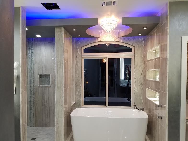 This is an example of a medium sized contemporary ensuite bathroom in Other with open cabinets, grey cabinets, a freestanding bath, a walk-in shower, a two-piece toilet, grey tiles, porcelain tiles, grey walls, porcelain flooring, an integrated sink and engineered stone worktops.