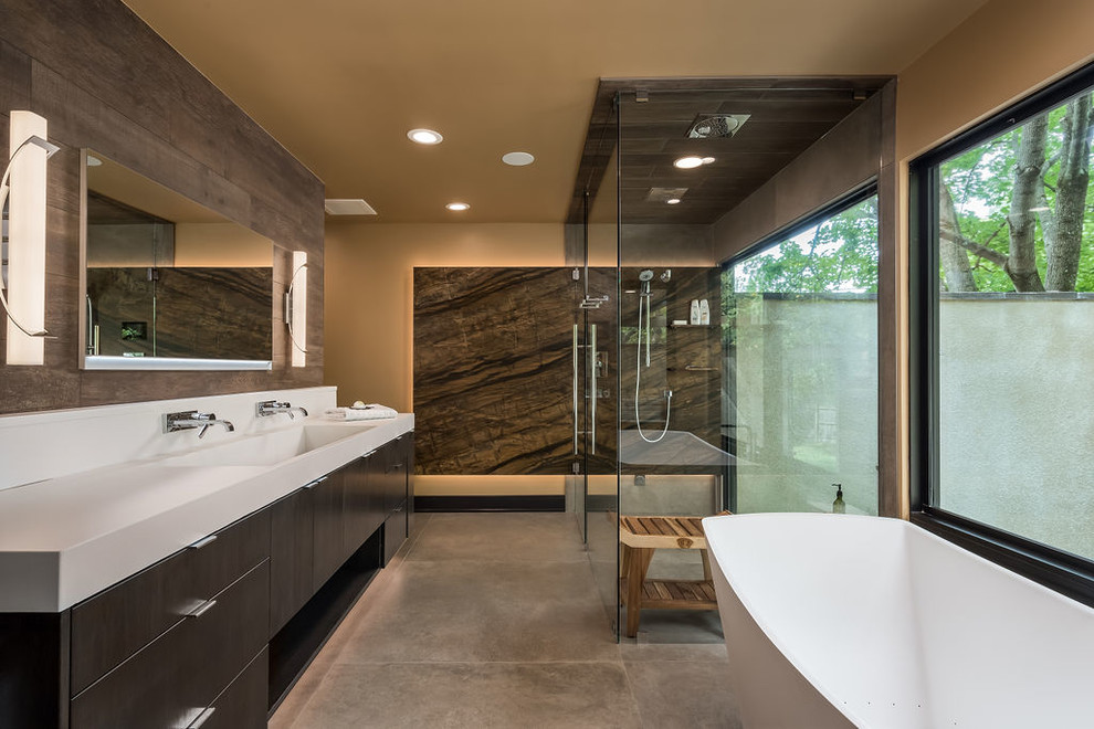 Bathroom - large contemporary master brown tile porcelain tile and gray floor bathroom idea in Columbus with flat-panel cabinets, dark wood cabinets, beige walls, an integrated sink, concrete countertops and a hinged shower door