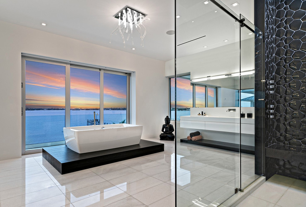Diseño de cuarto de baño principal contemporáneo con armarios con paneles lisos, puertas de armario blancas, bañera exenta y baldosas y/o azulejos negros