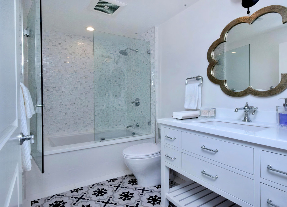 Cette image montre une salle d'eau méditerranéenne de taille moyenne avec un placard à porte shaker, des portes de placard blanches, une douche d'angle, WC à poser, un carrelage blanc, du carrelage en marbre, un mur blanc, un sol en marbre, un lavabo encastré, un plan de toilette en marbre, un sol multicolore, une cabine de douche à porte battante, un plan de toilette blanc, un banc de douche, meuble double vasque, meuble-lavabo encastré et un plafond décaissé.