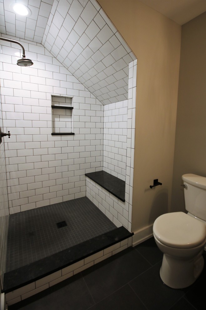 Inredning av ett klassiskt mellanstort badrum, med en dusch i en alkov, en toalettstol med separat cisternkåpa, vit kakel, tunnelbanekakel, grå väggar, skiffergolv, grått golv och dusch med gångjärnsdörr