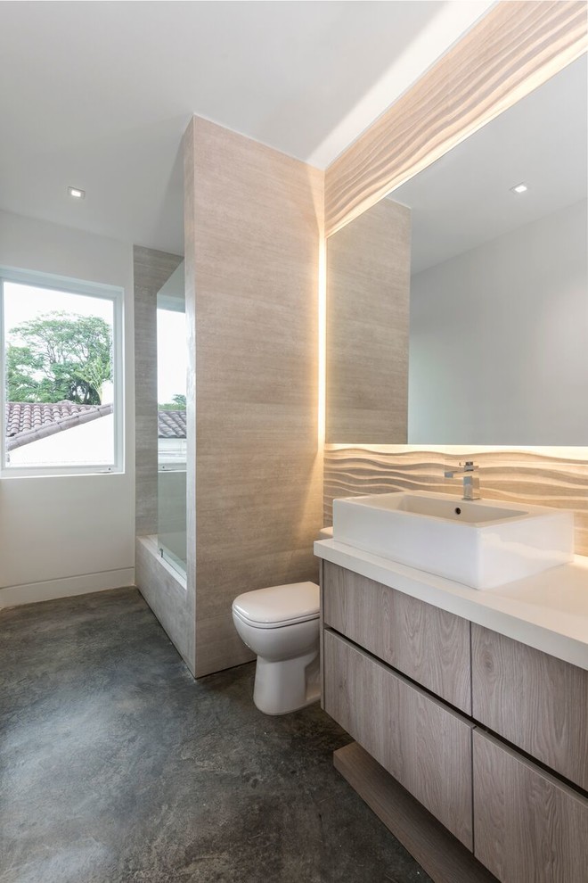 Example of a large trendy master concrete floor alcove shower design in Miami with a two-piece toilet, flat-panel cabinets, light wood cabinets, white walls, a vessel sink, quartz countertops and a hinged shower door