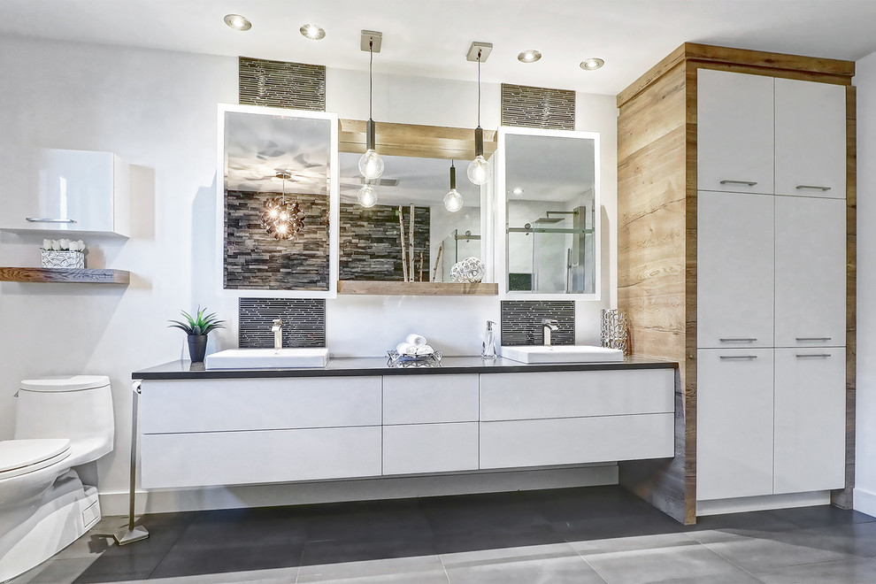 Foto de cuarto de baño principal contemporáneo de tamaño medio con armarios tipo vitrina, puertas de armario blancas, paredes blancas y suelo gris