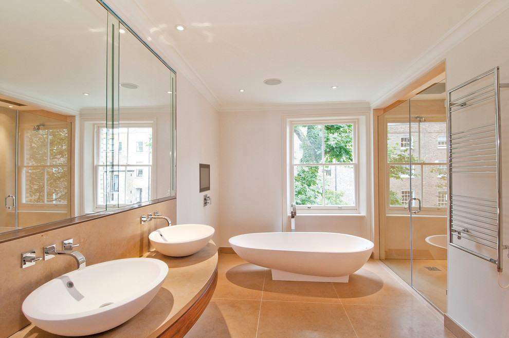 Imagen de cuarto de baño contemporáneo con bañera exenta, lavabo sobreencimera y ventanas
