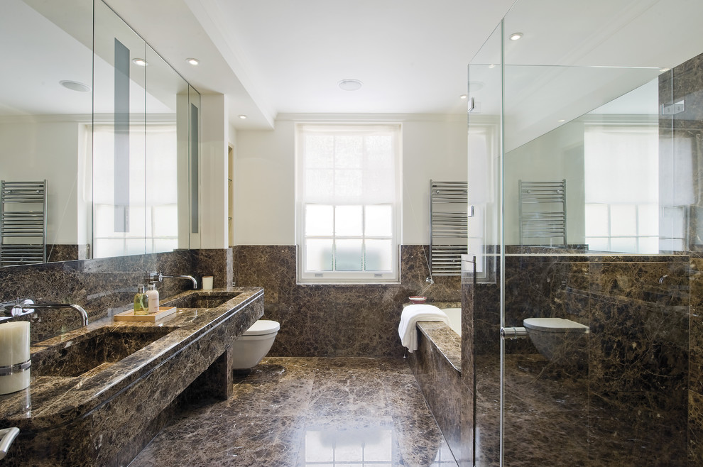 На фото: ванная комната в современном стиле с монолитной раковиной, полновстраиваемой ванной, угловым душем, инсталляцией и коричневой плиткой