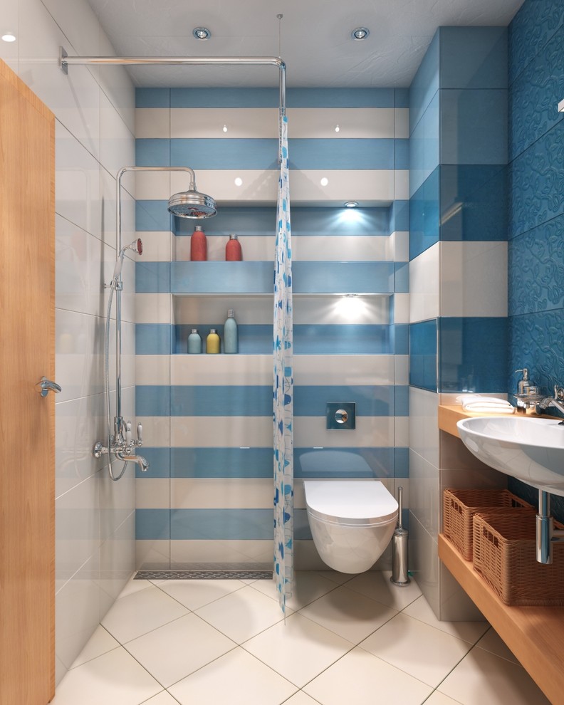 Inredning av ett medelhavsstil litet en-suite badrum, med öppna hyllor, en vägghängd toalettstol, keramikplattor, klinkergolv i keramik, träbänkskiva, skåp i slitet trä, en dusch/badkar-kombination, blå kakel, vita väggar och ett konsol handfat