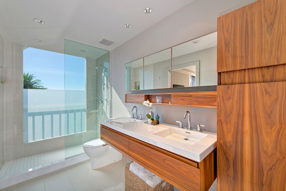 This is an example of a large contemporary shower room bathroom in San Diego with flat-panel cabinets, medium wood cabinets, an alcove shower, a one-piece toilet, grey tiles, cement tiles, grey walls, porcelain flooring, an integrated sink, engineered stone worktops, grey floors and an open shower.
