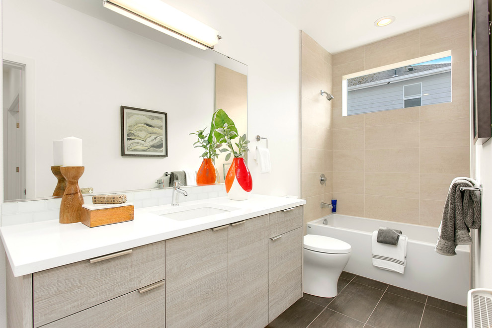 Example of a mid-sized trendy 3/4 white tile and subway tile slate floor bathroom design in Seattle with flat-panel cabinets, gray cabinets, a two-piece toilet, white walls, an undermount sink and solid surface countertops