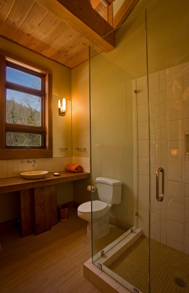 Cette image montre une salle de bain principale craftsman en bois brun de taille moyenne avec une vasque, un placard en trompe-l'oeil, un plan de toilette en bois, une douche d'angle, WC séparés, un carrelage beige, des carreaux de céramique, un mur beige et parquet clair.