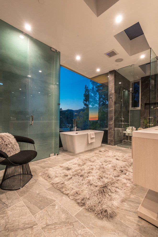 Inspiration for an expansive contemporary ensuite bathroom in Los Angeles with louvered cabinets, light wood cabinets, a freestanding bath, a double shower, a bidet, beige tiles, stone tiles, white walls, a submerged sink and engineered stone worktops.