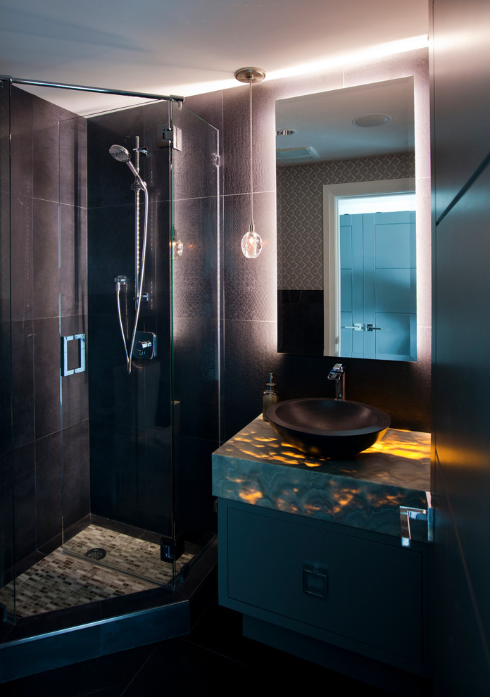 На фото: ванная комната среднего размера в современном стиле с настольной раковиной, плоскими фасадами, серыми фасадами, столешницей из оникса, раздельным унитазом, черной плиткой, керамогранитной плиткой, черными стенами и полом из керамогранита