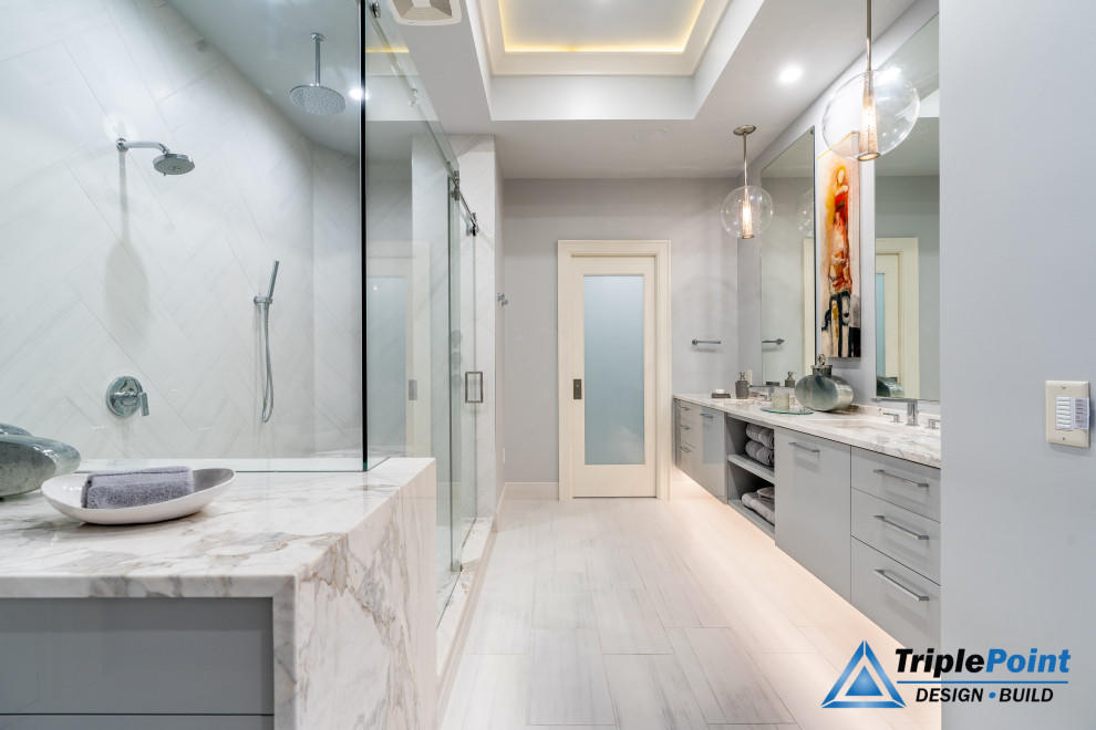 Modern inredning av ett stort grå grått en-suite badrum, med släta luckor, grå skåp, granitbänkskiva, en hörndusch, grå väggar, ett undermonterad handfat, grått golv och dusch med skjutdörr