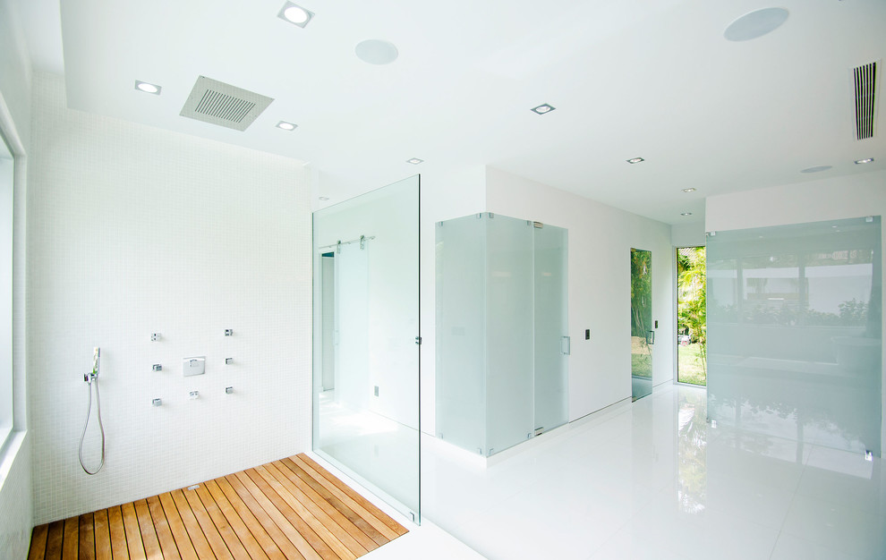 На фото: огромная главная ванная комната в стиле модернизм с фасадами островного типа, серыми фасадами, отдельно стоящей ванной, душевой комнатой, полом из керамогранита, настольной раковиной, столешницей из дерева, белым полом и коричневой столешницей с