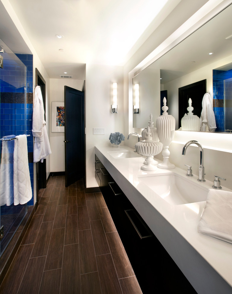 Design ideas for a large contemporary ensuite bathroom in San Francisco with flat-panel cabinets, dark wood cabinets, an alcove shower, blue tiles, metro tiles, dark hardwood flooring, a submerged sink, white walls, solid surface worktops and brown floors.