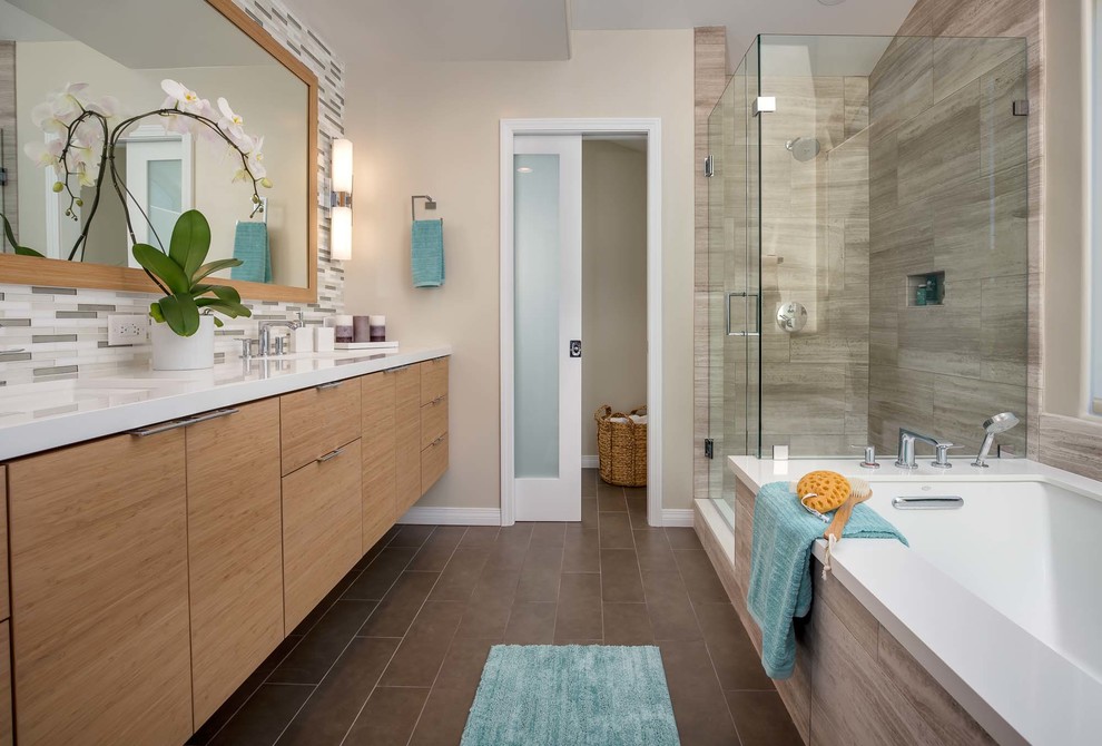 Design ideas for a large contemporary ensuite bathroom in Los Angeles with flat-panel cabinets, light wood cabinets, a built-in bath, a corner shower, a two-piece toilet, multi-coloured tiles, glass tiles, multi-coloured walls, a submerged sink, engineered stone worktops, brown floors, a hinged door and porcelain flooring.
