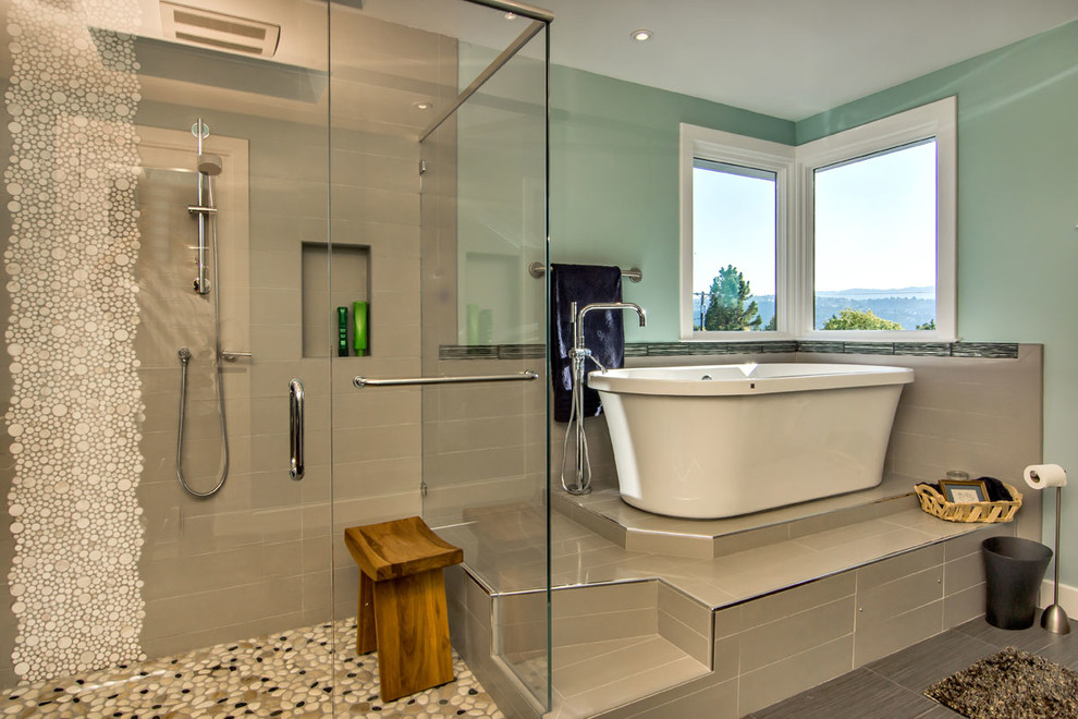 Foto på ett funkis badrum, med ett fristående badkar, en hörndusch och beige kakel