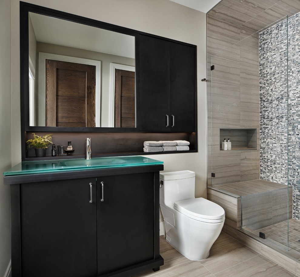 Foto på ett funkis badrum, med släta luckor, svarta skåp, en dusch i en alkov, svart och vit kakel, grå kakel, beige väggar, ett integrerad handfat, bänkskiva i glas och grått golv