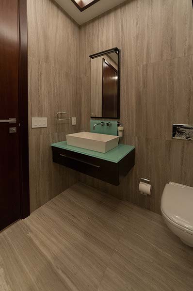 Example of a mid-sized trendy 3/4 gray tile and stone slab marble floor bathroom design in Miami with a wall-mount sink, flat-panel cabinets, dark wood cabinets, glass countertops, a wall-mount toilet and gray walls