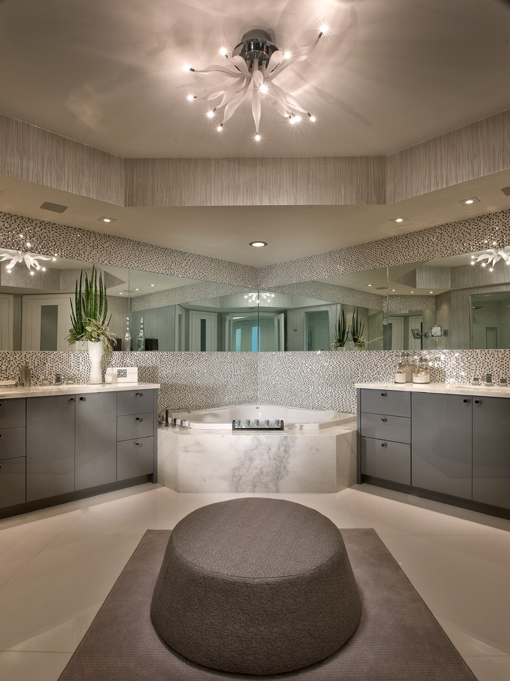 На фото: ванная комната в современном стиле с плоскими фасадами, серыми фасадами, угловой ванной и белой плиткой с