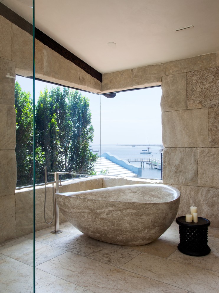 Свежая идея для дизайна: ванная комната в современном стиле с отдельно стоящей ванной, угловым душем, бежевой плиткой и каменной плиткой - отличное фото интерьера