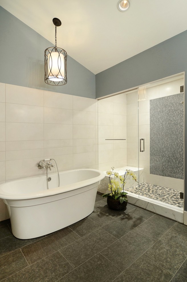 Ejemplo de cuarto de baño principal actual con bañera exenta, ducha empotrada, baldosas y/o azulejos grises, baldosas y/o azulejos de piedra y paredes grises
