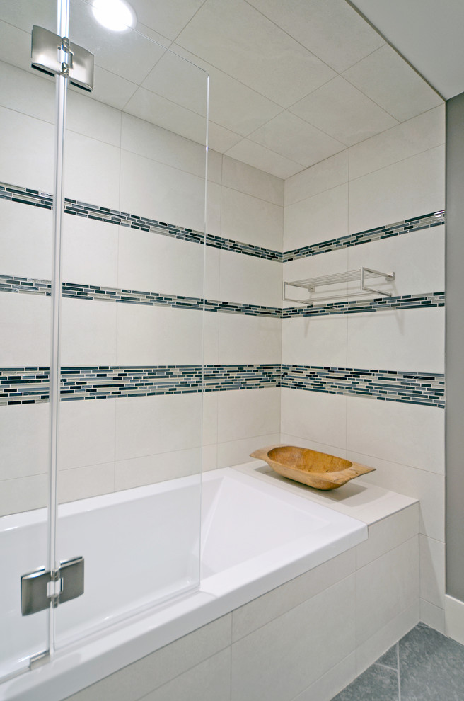 Cette photo montre une salle de bain tendance avec une baignoire posée, un carrelage bleu, mosaïque et un mur gris.