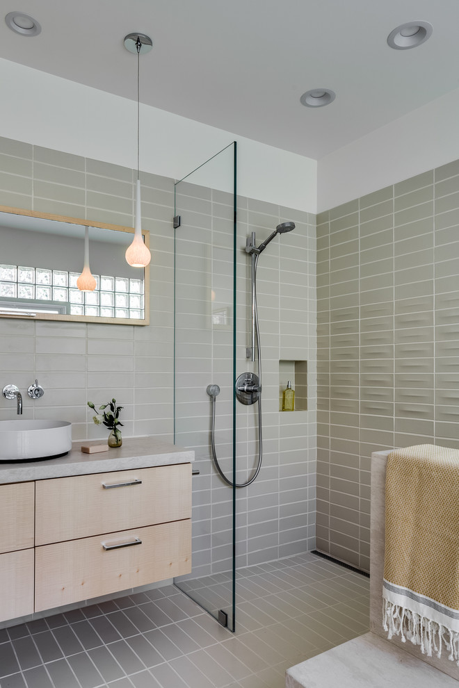Example of a mid-sized minimalist beige tile and ceramic tile ceramic tile and beige floor bathroom design in San Francisco with flat-panel cabinets, light wood cabinets, a one-piece toilet, white walls, a vessel sink and limestone countertops