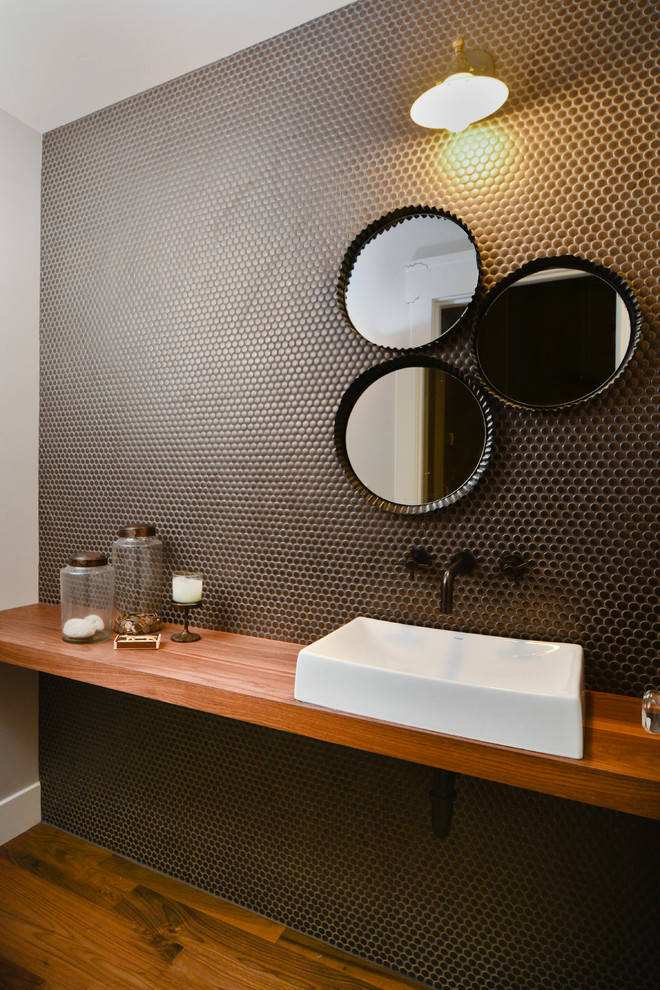 Cette image montre une salle de bain design avec une vasque et un plan de toilette en bois.