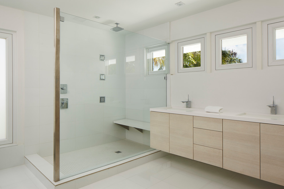 Réalisation d'une salle de bain design en bois clair avec un lavabo encastré, un placard à porte plane, une douche d'angle et un carrelage blanc.