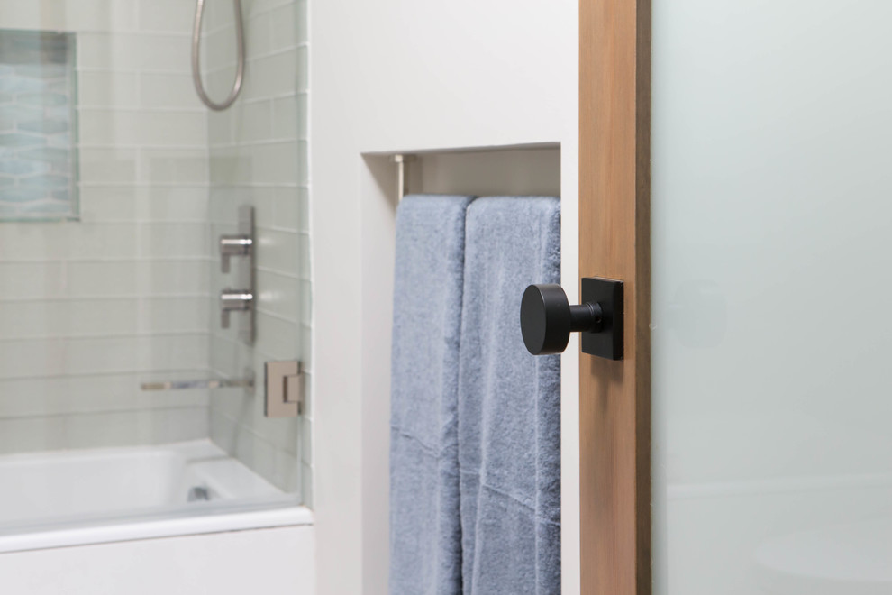 Ejemplo de cuarto de baño contemporáneo con bañera empotrada, combinación de ducha y bañera, baldosas y/o azulejos de vidrio, aseo y ducha y ducha con puerta con bisagras