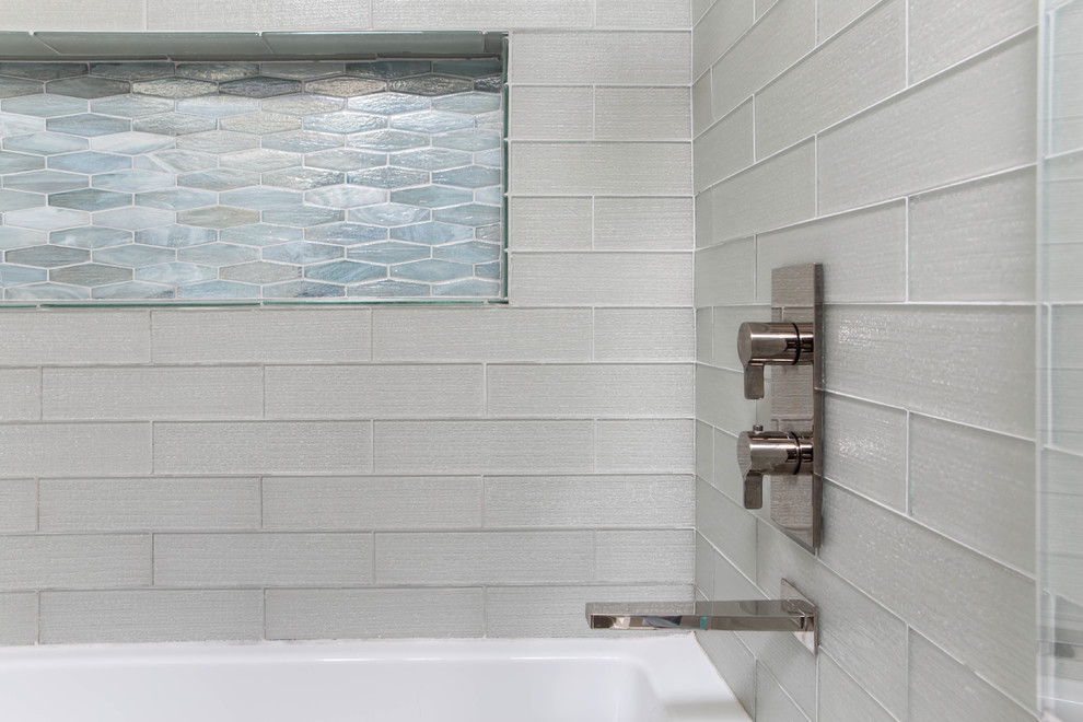 Cette image montre une salle d'eau design avec une baignoire en alcôve, un combiné douche/baignoire, un carrelage en pâte de verre et une cabine de douche à porte battante.