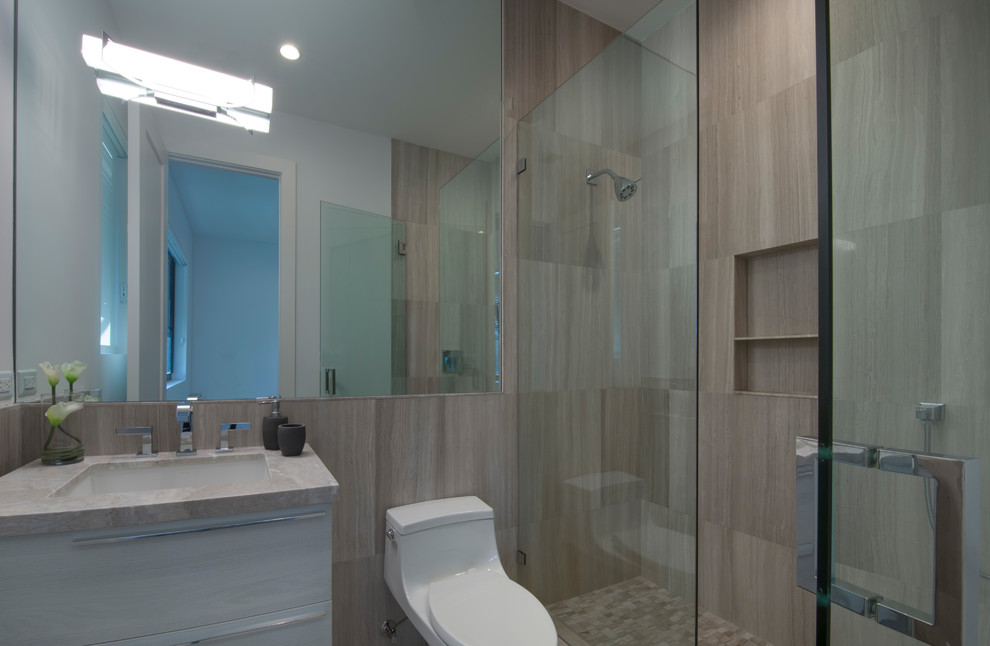 Photo of a medium sized contemporary bathroom in Miami with flat-panel cabinets, brown cabinets, an alcove shower, a one-piece toilet, brown tiles, grey walls, a wall-mounted sink and beige floors.