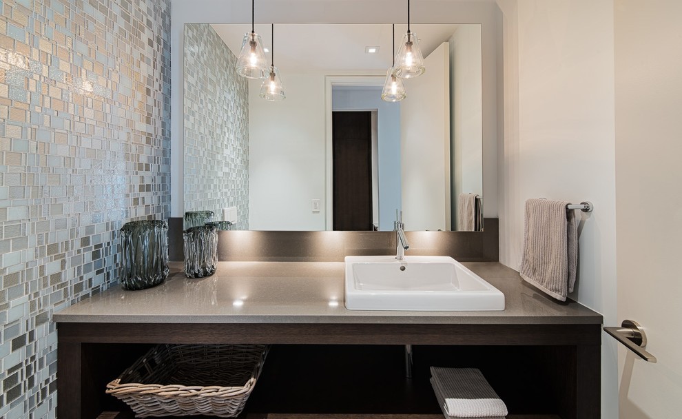 Diseño de cuarto de baño actual con lavabo sobreencimera, armarios con paneles lisos, puertas de armario blancas, encimera de granito y baldosas y/o azulejos de vidrio