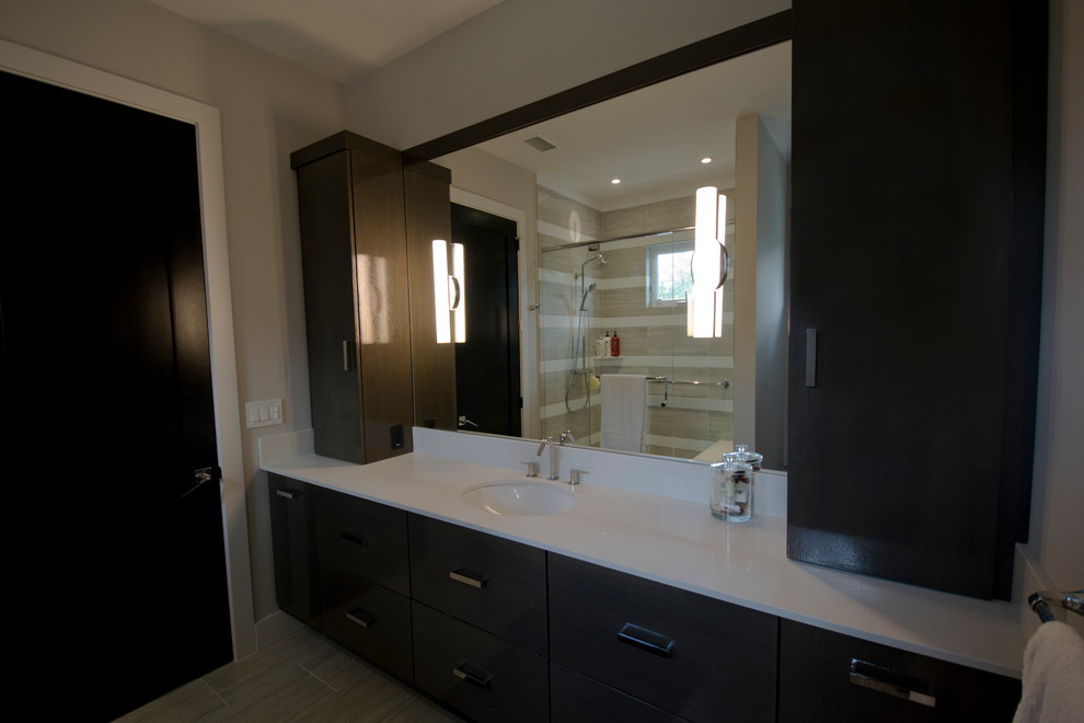 Inspiration pour une très grande salle de bain design en bois foncé avec un placard en trompe-l'oeil, un carrelage gris, un lavabo encastré et un plan de toilette en quartz modifié.