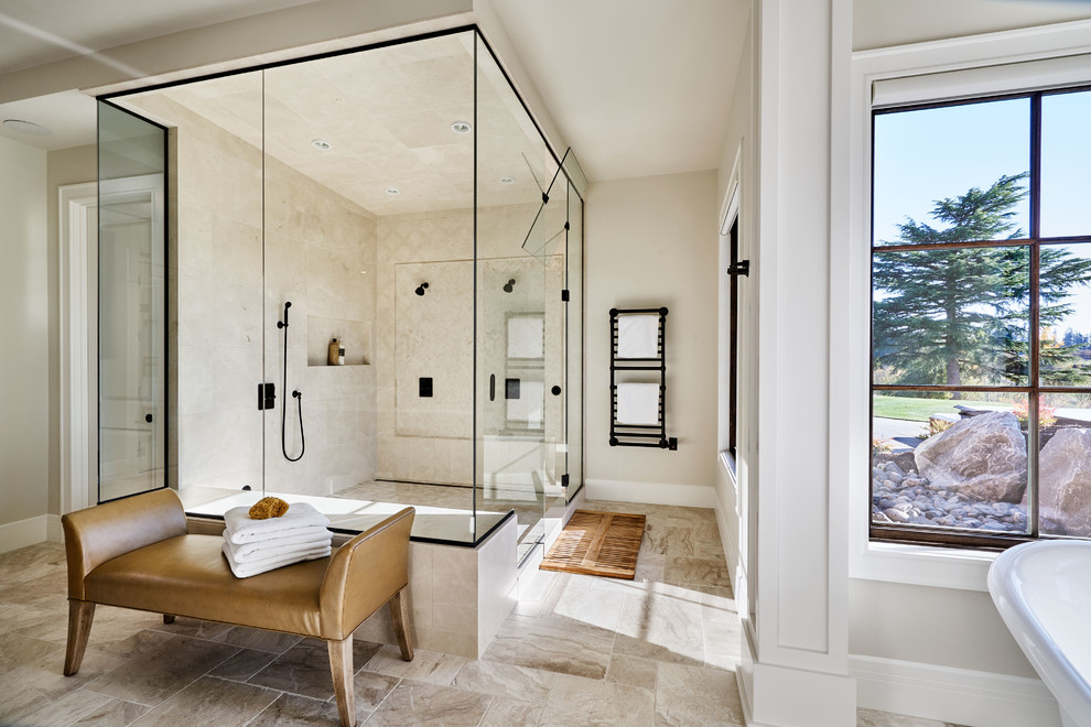 На фото: большая главная ванная комната в стиле кантри с отдельно стоящей ванной, угловым душем, каменной плиткой, полом из травертина, душем с распашными дверями, бежевой плиткой, бежевыми стенами и коричневым полом с