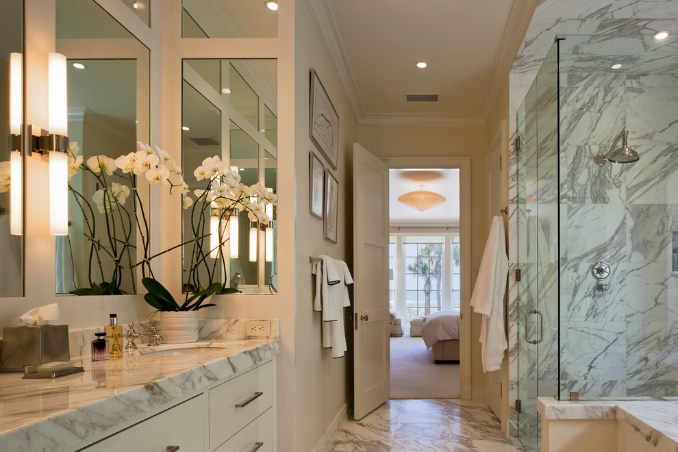 Example of a transitional master white tile and stone tile marble floor corner shower design in Jacksonville with beaded inset cabinets, white cabinets, an undermount tub, a one-piece toilet, yellow walls, an undermount sink and marble countertops