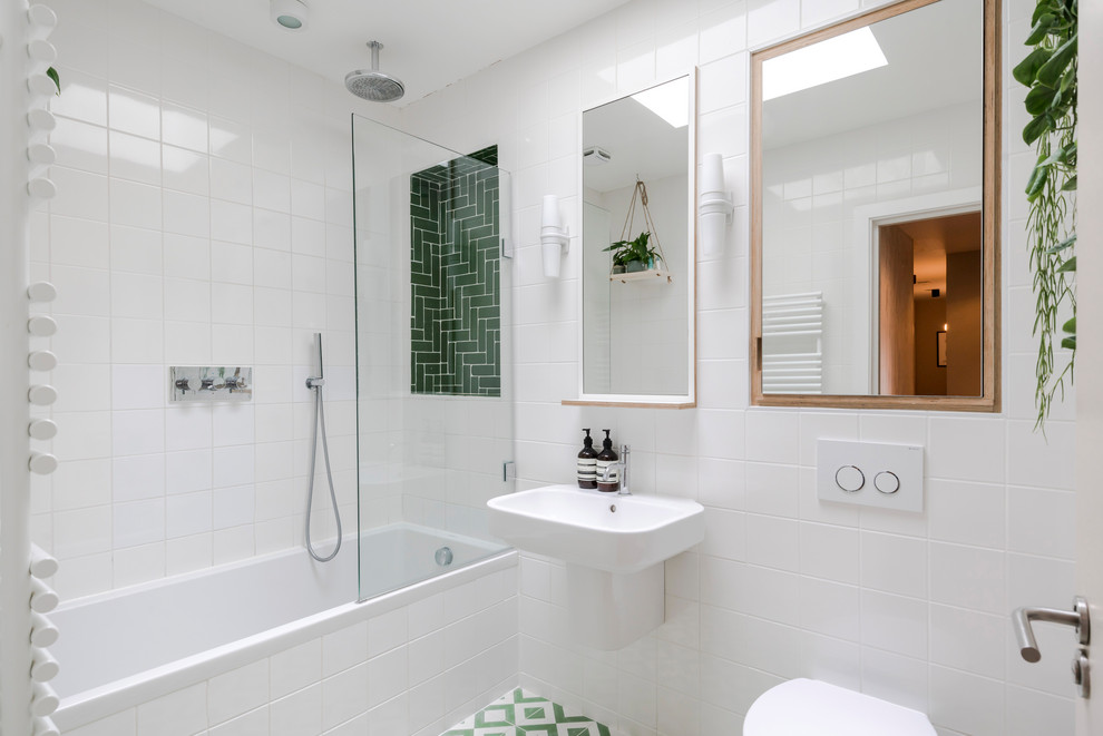 Immagine di una stanza da bagno contemporanea con vasca ad alcova, piastrelle bianche, lavabo sospeso e pavimento multicolore