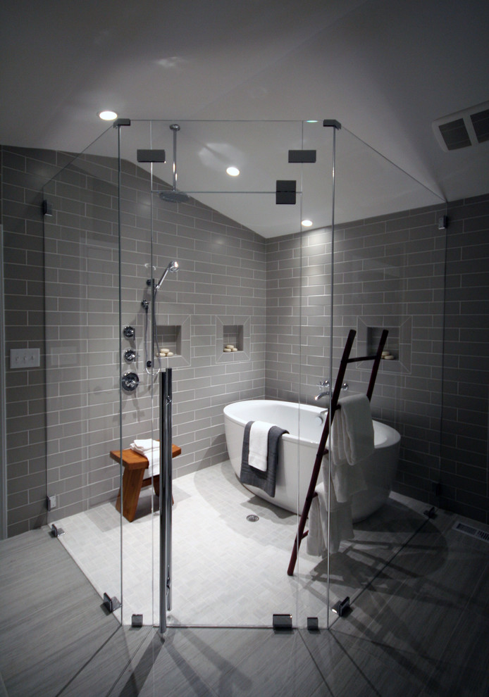 Cette photo montre une salle de bain principale tendance avec une baignoire indépendante, une douche à l'italienne, un carrelage gris et un sol en carrelage de porcelaine.