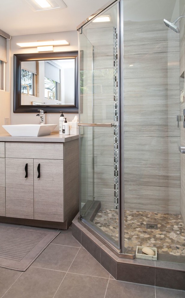 Exempel på ett mellanstort modernt badrum med dusch, med ett fristående handfat, släta luckor, skåp i mörkt trä, bänkskiva i kvarts, en hörndusch, en toalettstol med hel cisternkåpa, grå kakel, kakel i småsten, grå väggar och klinkergolv i keramik