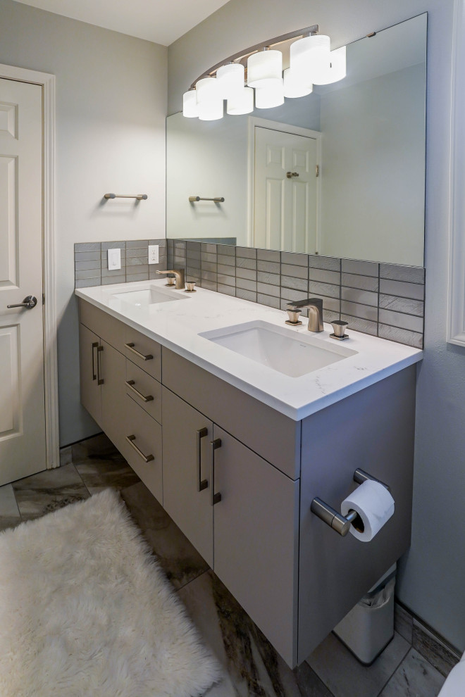 Photo of a large contemporary ensuite bathroom in Seattle with flat-panel cabinets, grey cabinets, a freestanding bath, a corner shower, a one-piece toilet, white tiles, porcelain tiles, grey walls, ceramic flooring, a submerged sink, solid surface worktops, grey floors, a hinged door, white worktops, double sinks and a floating vanity unit.