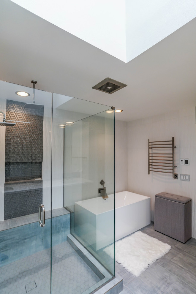 Стильный дизайн: большая главная ванная комната в современном стиле с плоскими фасадами, серыми фасадами, отдельно стоящей ванной, угловым душем, унитазом-моноблоком, белой плиткой, керамогранитной плиткой, серыми стенами, полом из керамической плитки, врезной раковиной, столешницей из искусственного камня, серым полом, душем с распашными дверями, белой столешницей, тумбой под две раковины и подвесной тумбой - последний тренд