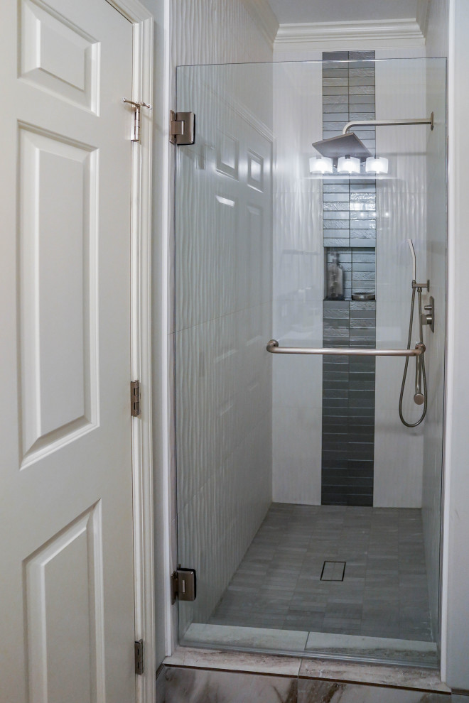 Bild på ett stort funkis vit vitt en-suite badrum, med släta luckor, grå skåp, ett fristående badkar, en hörndusch, en toalettstol med hel cisternkåpa, vit kakel, porslinskakel, grå väggar, klinkergolv i keramik, ett undermonterad handfat, bänkskiva i akrylsten, grått golv och dusch med gångjärnsdörr