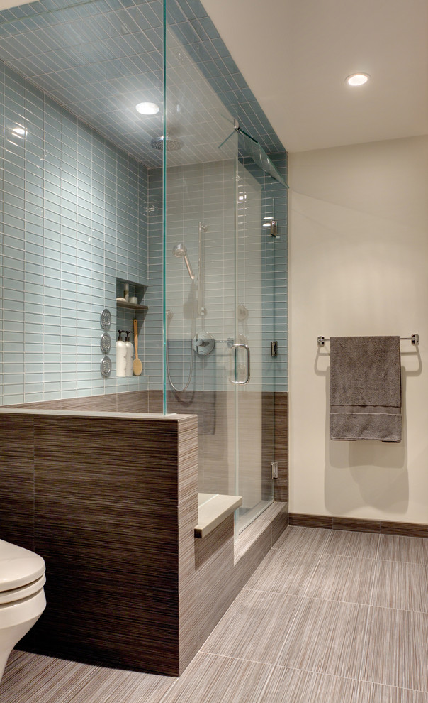 This is an example of a medium sized contemporary ensuite bathroom in Los Angeles with flat-panel cabinets, an alcove shower, a one-piece toilet, blue tiles, glass tiles, beige walls and porcelain flooring.