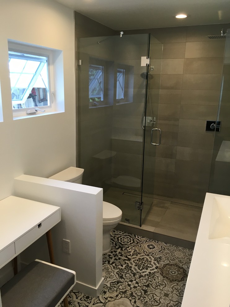 Inspiration for a contemporary ensuite bathroom in Milwaukee with flat-panel cabinets, grey cabinets, an alcove shower, beige tiles, porcelain tiles, white walls, ceramic flooring, an integrated sink and solid surface worktops.