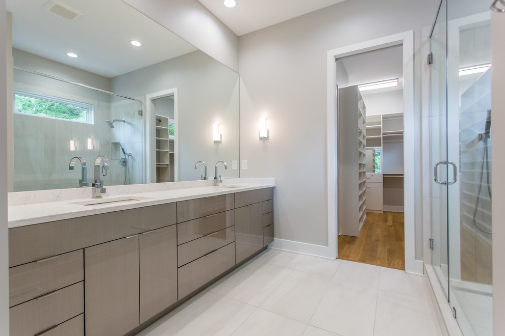 Example of a large trendy 3/4 white tile and porcelain tile medium tone wood floor and white floor alcove shower design in Atlanta with flat-panel cabinets, beige cabinets, a one-piece toilet, white walls, an undermount sink, quartz countertops and a hinged shower door